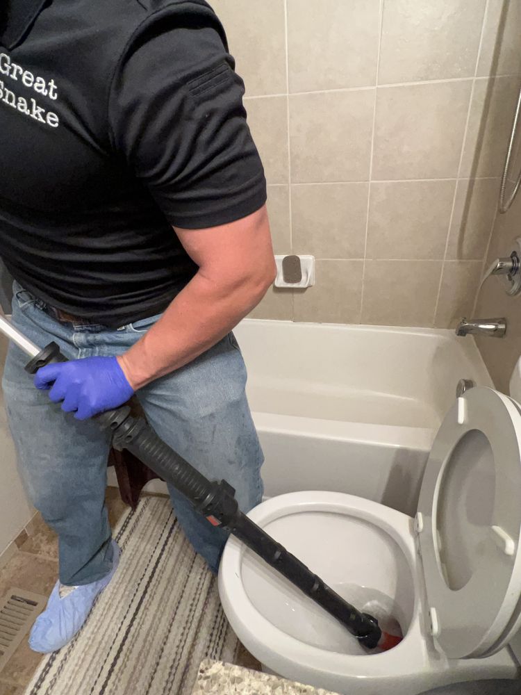 Plumber clearing a bathtub drain line
